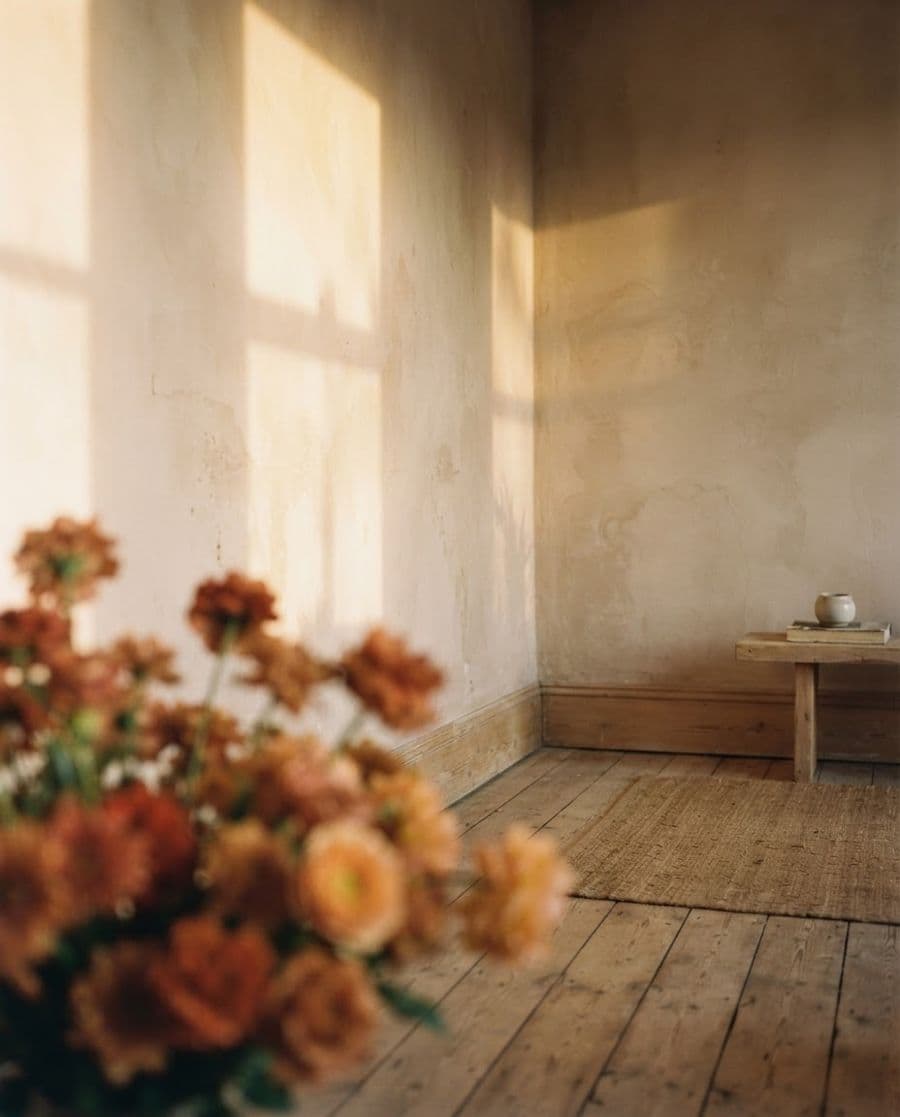 A warm room in late light, flowers on the floor