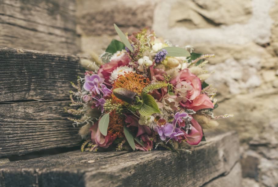 A loose, dried-look bouquet on a stone step