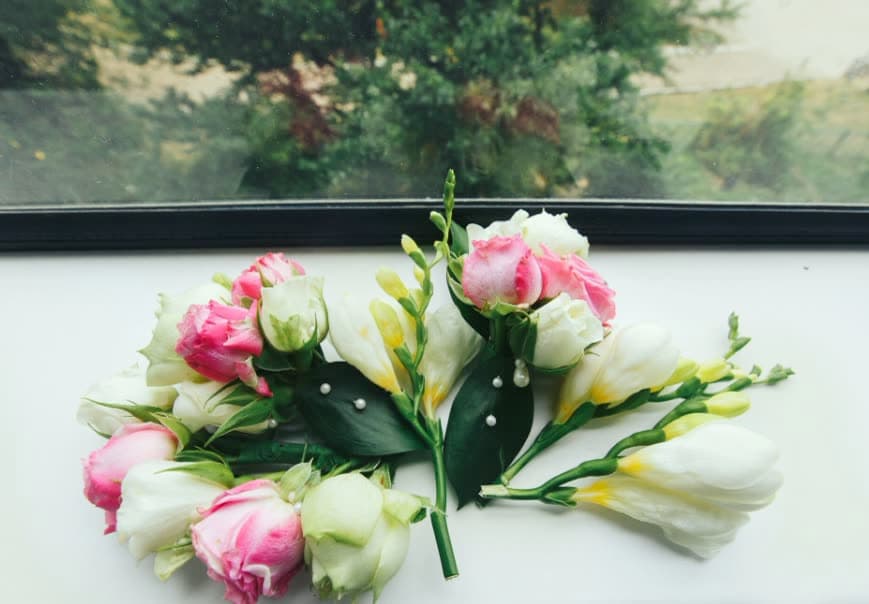 A spray of pink and cream lisianthus on a windowsill